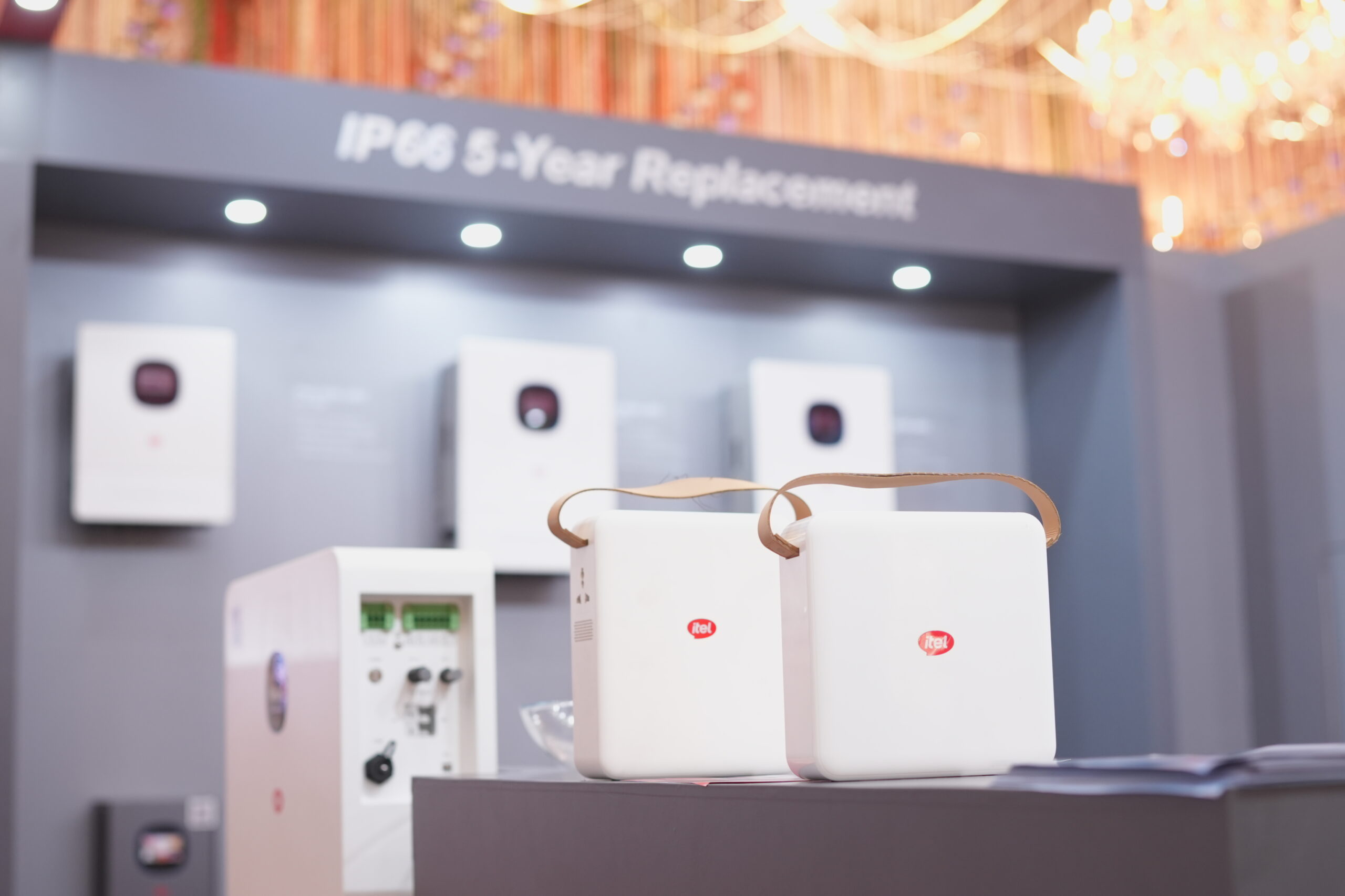 Wide view of itel Energy exhibition stall fabrication with red overhead branding and grey inverter display zones