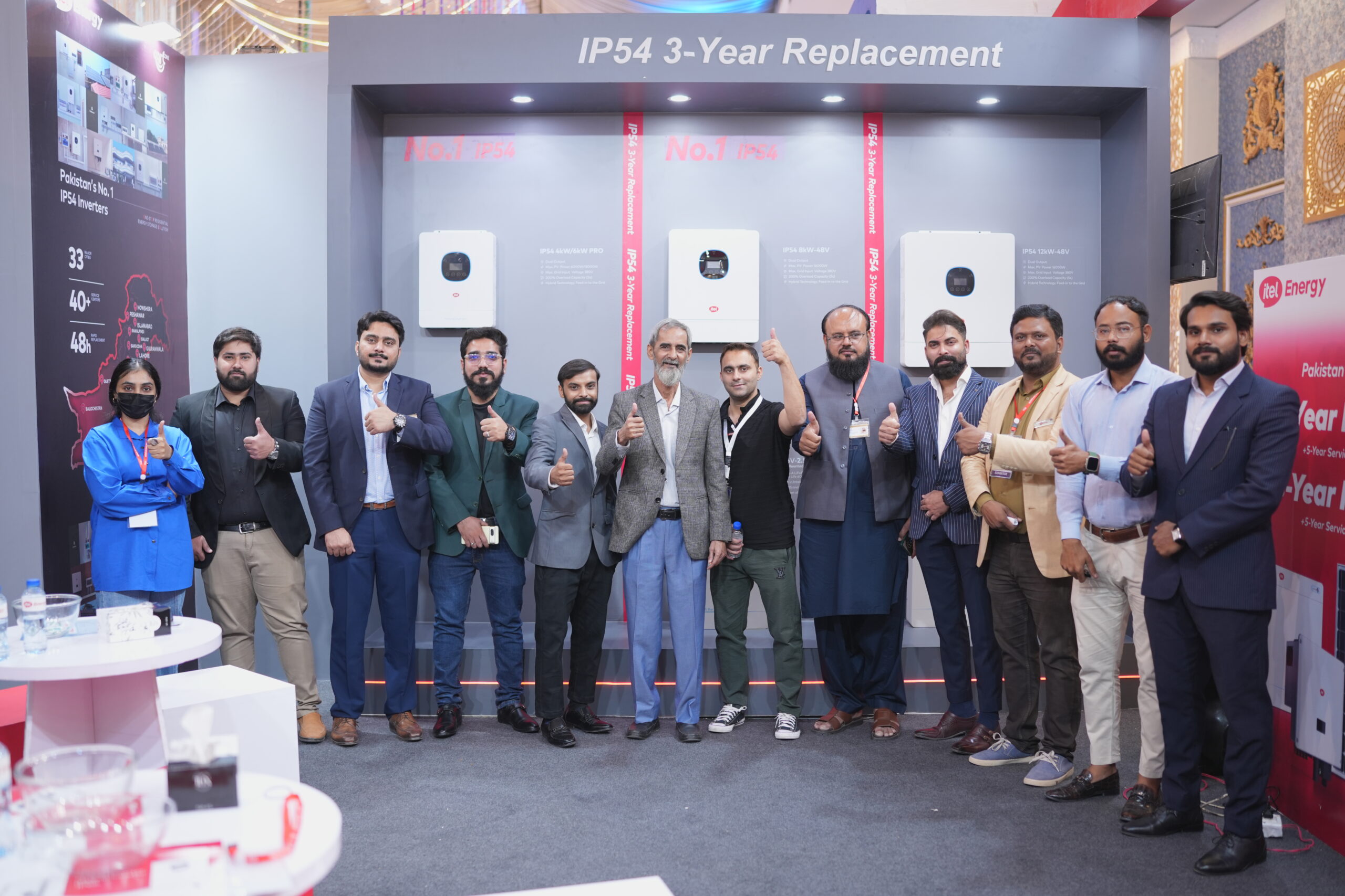 Business representatives at itel Energy exhibition booth exchanging branded presentation materials
