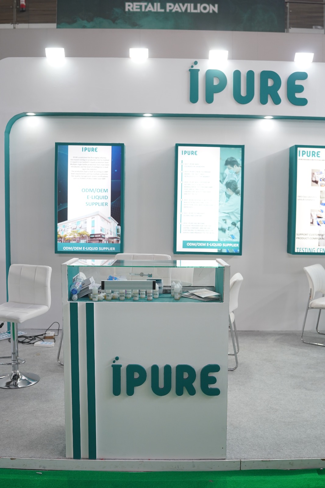 Branded iPURE glass display counter showing product samples and illuminated information panels